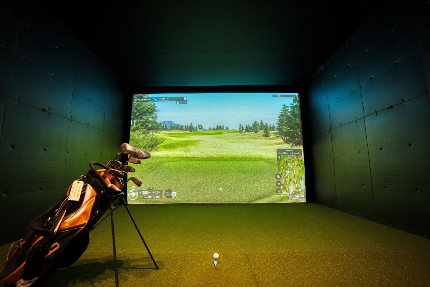 Indoor golf simulator with projected course on screen